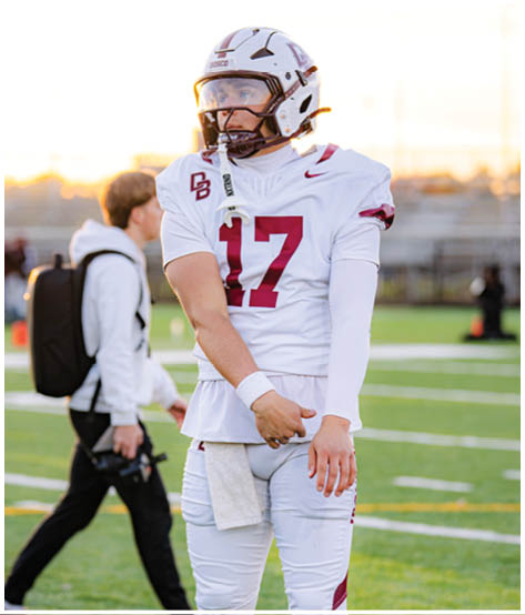 A football player wearing a blue and red jersey. Description generated by AI