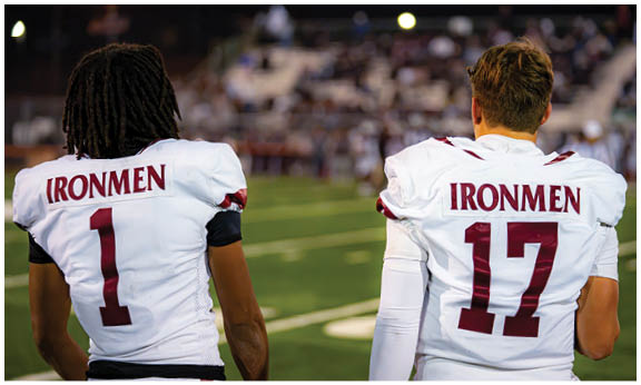 A football player wearing a blue and red jersey. Description generated by AI