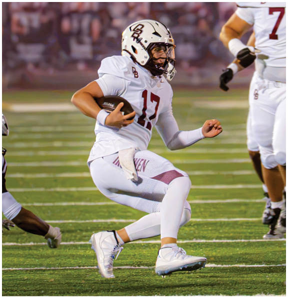 A football player wearing a blue and red jersey. Description generated by AI