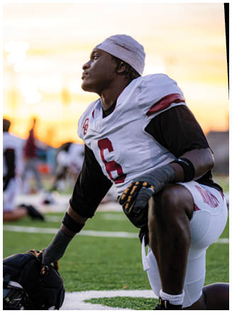 A football player wearing a blue and red jersey. Description generated by AI