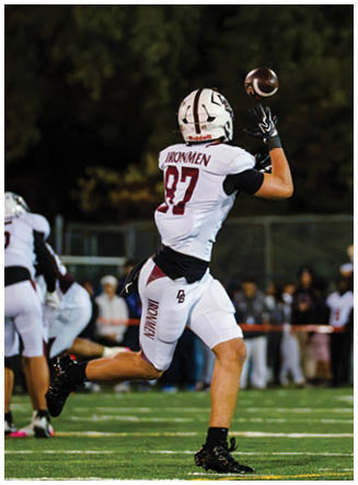 A football player wearing a blue and red jersey. Description generated by AI