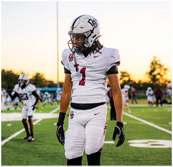 A football player wearing a blue and red jersey. Description generated by AI