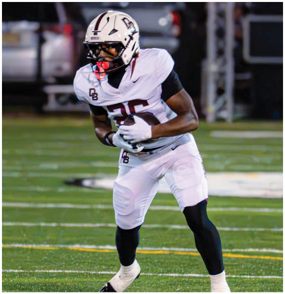 A football player wearing a blue and red jersey. Description generated by AI