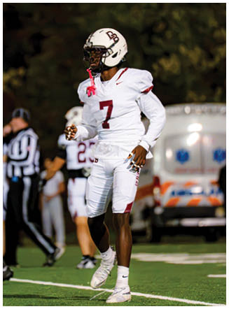 A football player wearing a blue and red jersey. Description generated by AI