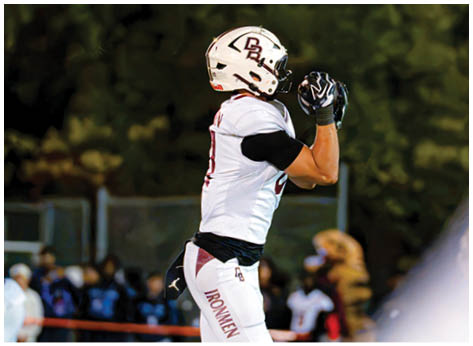 A football player wearing a blue and red jersey. Description generated by AI