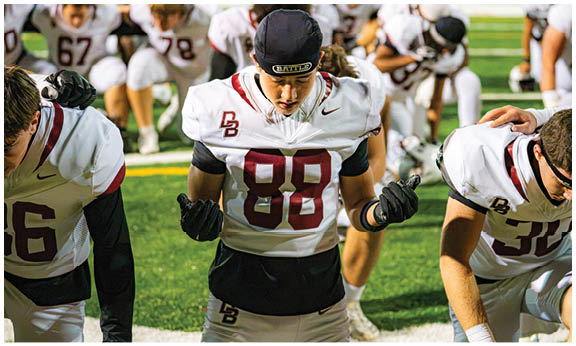 A football player wearing a blue and red jersey. Description generated by AI