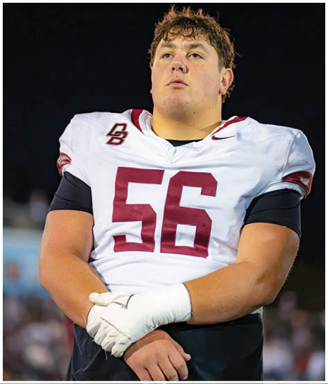A football player wearing a blue and red jersey. Description generated by AI