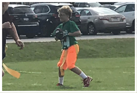 A football player wearing a blue and red jersey. Description generated by AI