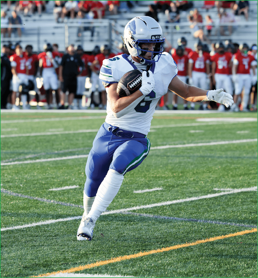 A football player running with a football. Description generated by AI