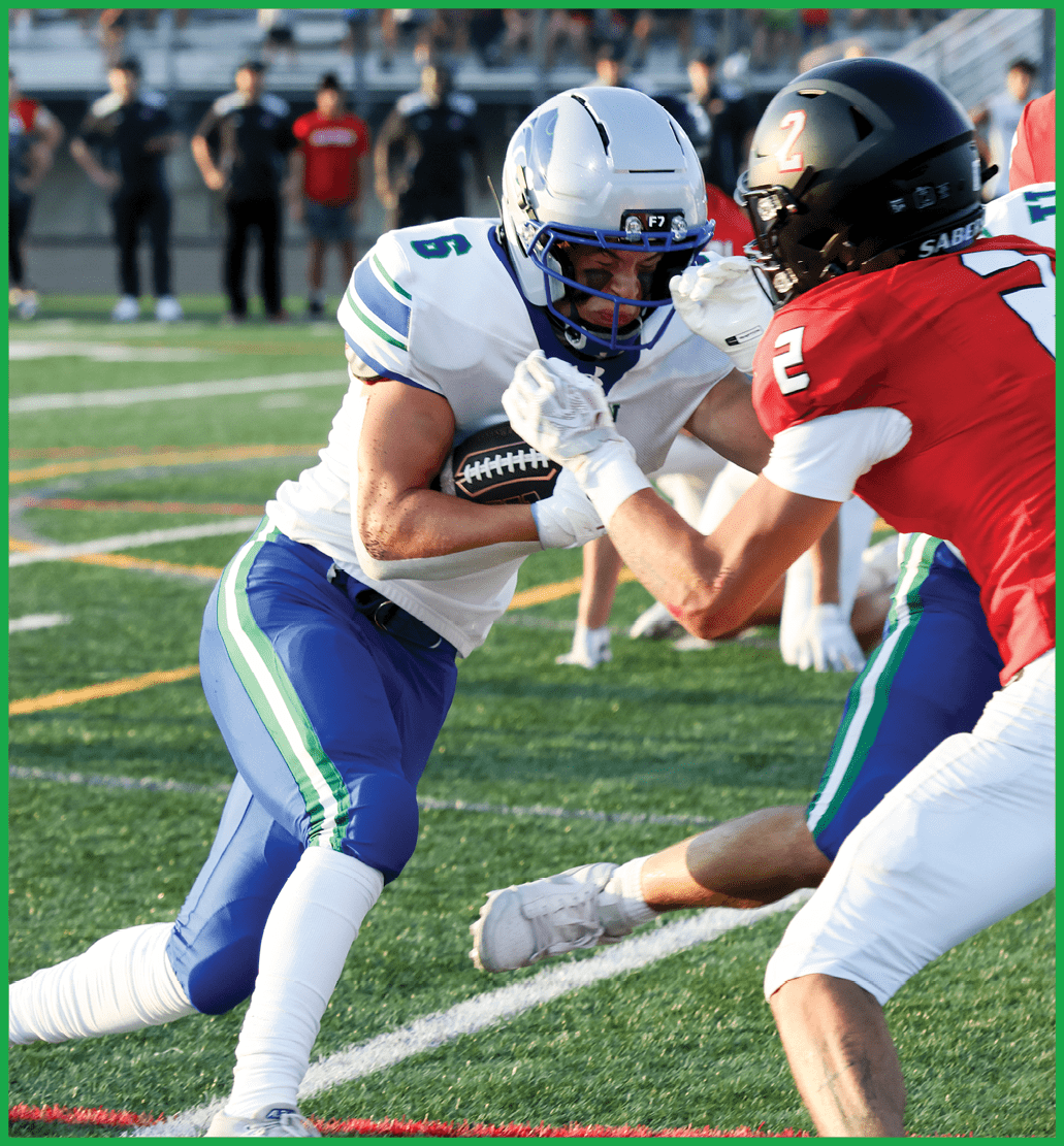 A football player in a green jersey is running with the ball. Description generated by AI