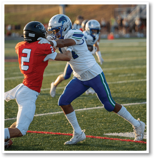 A football player wearing a black jersey with the number 6 on it. Description generated by AI