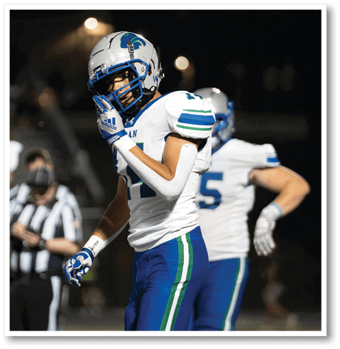A football player wearing a black jersey with the number 6 on it. Description generated by AI