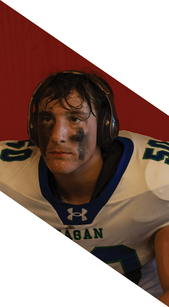 A football player wearing a black helmet and white jersey is holding a football in his hands. AI generated content