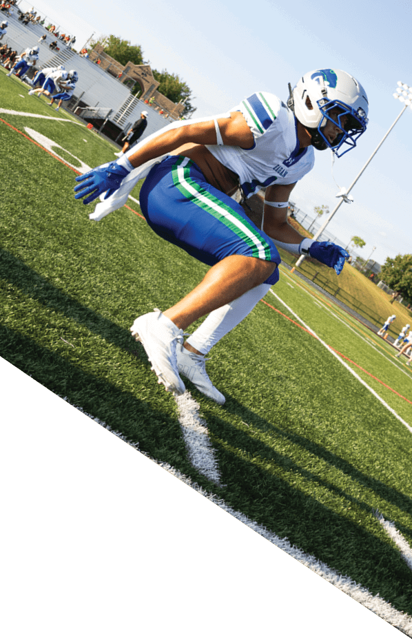 A football player is kneeling on the field, holding his helmet in his hands. AI generated content