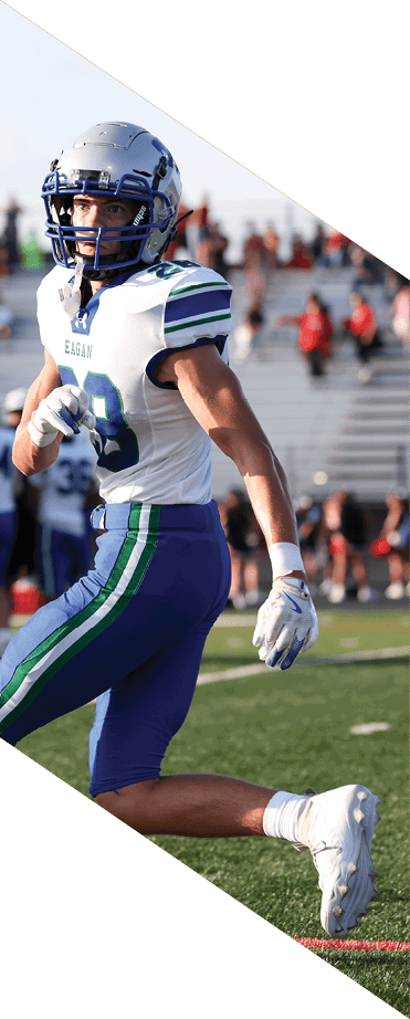 A football player wearing a helmet and white uniform is holding his helmet above his head. AI generated content