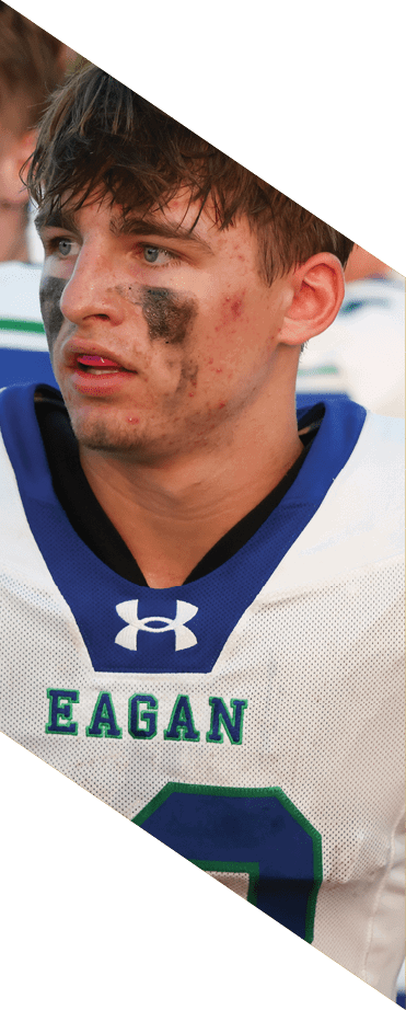A football player wearing a helmet and white uniform is holding his helmet above his head. AI generated content
