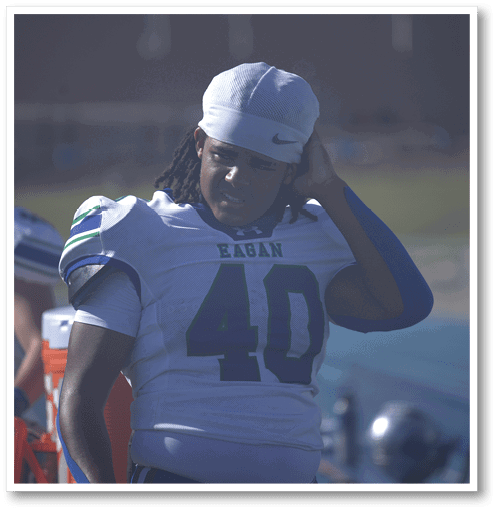 A football player wearing a black jersey with the number 6 on it. Description generated by AI