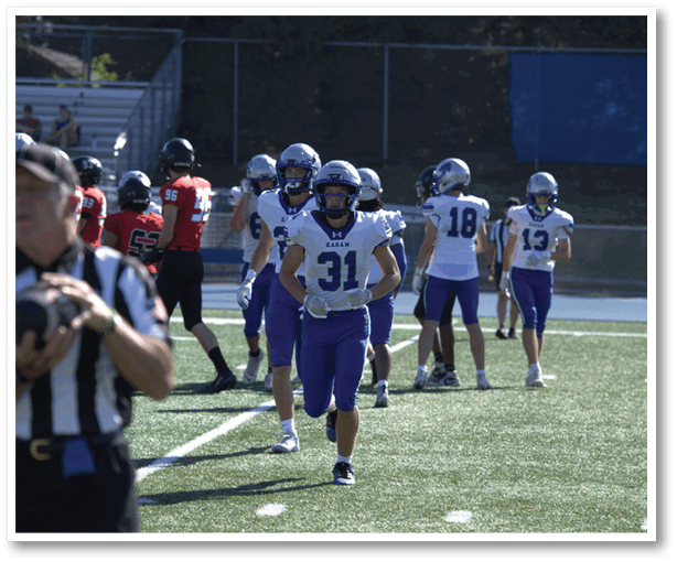 A football player is kicking a football on a field. Description generated by AI