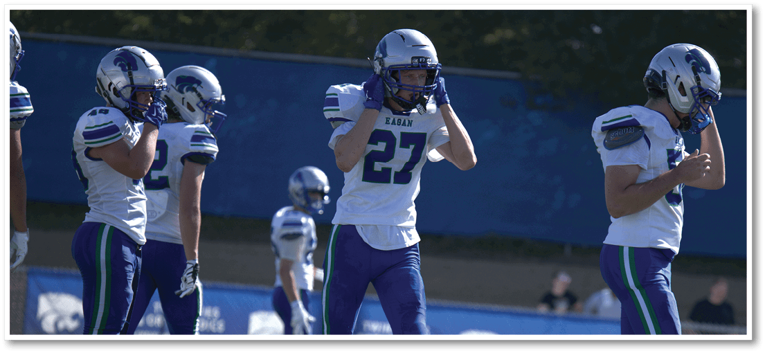 A group of football players on a field. Description generated by AI