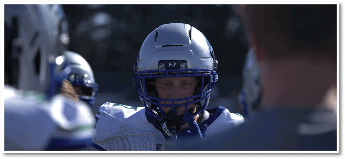 A group of football players on a field. Description generated by AI