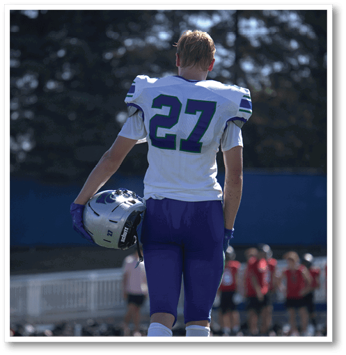 A football player wearing a black jersey with the number 6 on it. Description generated by AI