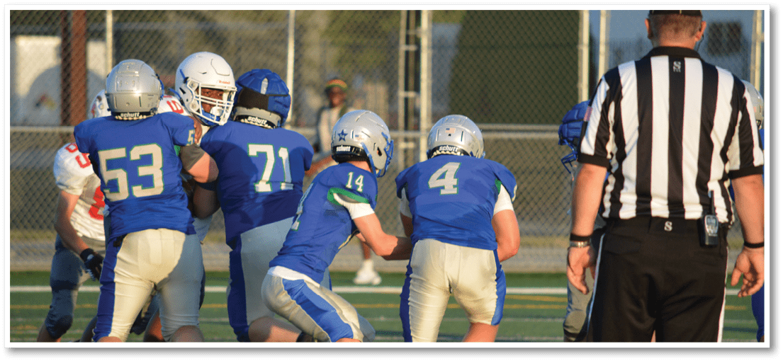 A group of football players on a field. Description generated by AI
