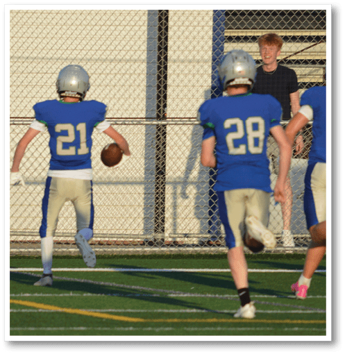 A football player wearing a black jersey with the number 6 on it. Description generated by AI