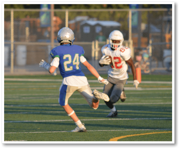 A football player is kicking a football on a field. Description generated by AI