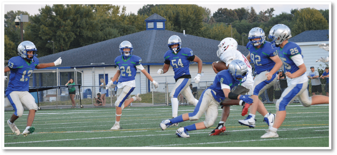 A group of football players on a field. Description generated by AI