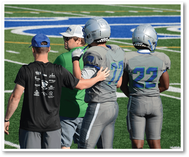 A group of football players wearing black jerseys with the number 3 on them. Description generated by AI