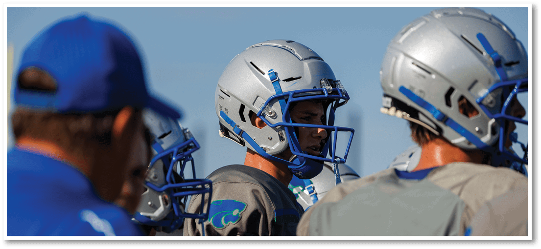 A group of football players on a field. Description generated by AI