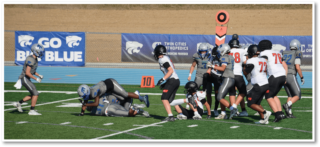 A group of football players on a field. Description generated by AI