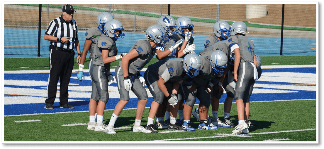 A group of football players on a field. Description generated by AI