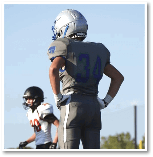 A football player wearing a black jersey with the number 6 on it. Description generated by AI