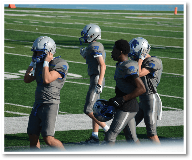 A group of football players wearing black jerseys with the number 3 on them. Description generated by AI