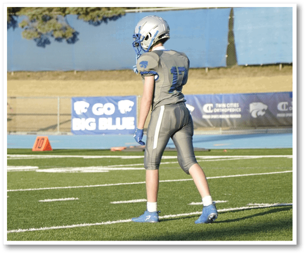 A football player is kicking a football on a field. Description generated by AI