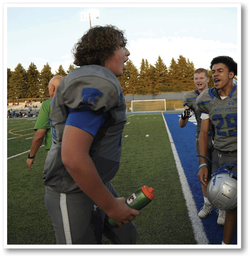 Two football players wearing black jerseys with the number 11 on them. Description generated by AI