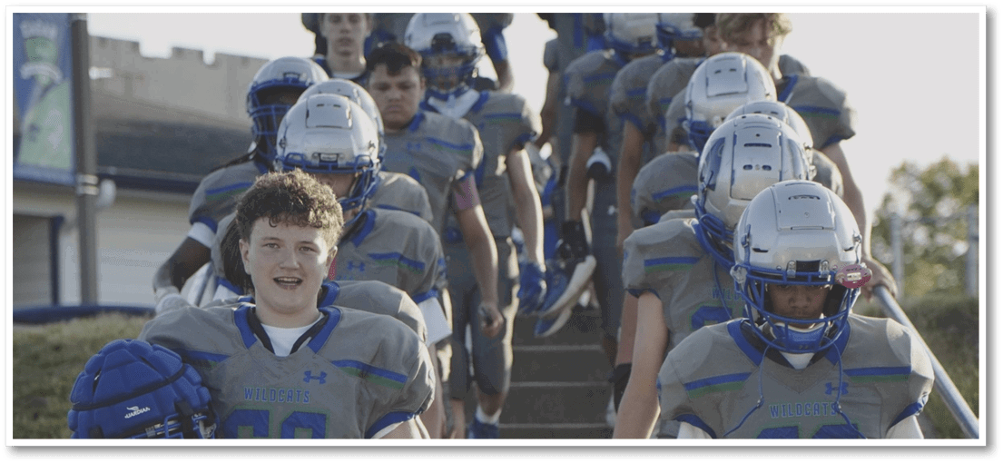 A group of football players on a field. Description generated by AI