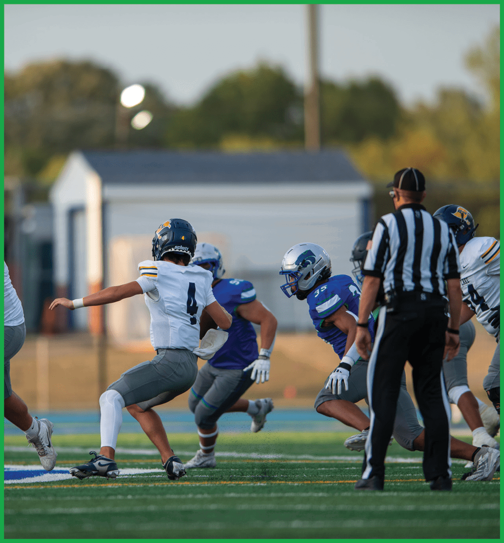 A football player running with a football. Description generated by AI
