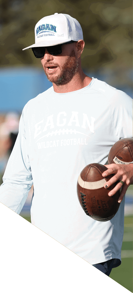 A man catches a football in a field while another man watches. AI generated content