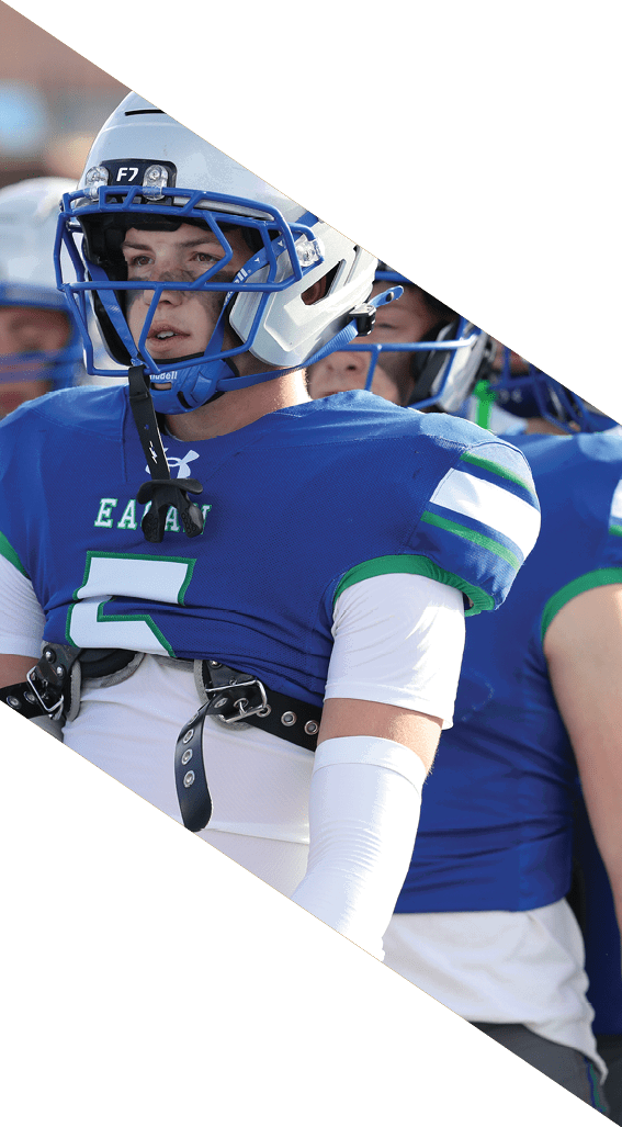 A football player wearing a black helmet and white jersey is holding a football in his hands. AI generated content