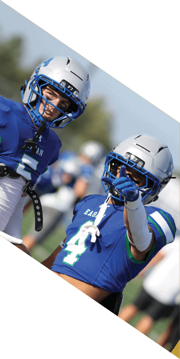 Two football players are on the field, one jumping in the air while the other is running. A referee is also present, watching the play. AI generated content