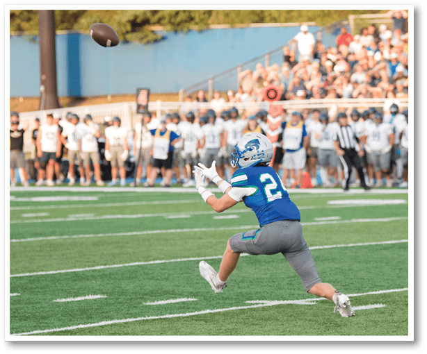 A football player is kicking a football on a field. Description generated by AI