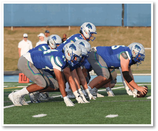 A group of people playing football on a field. Description generated by AI
