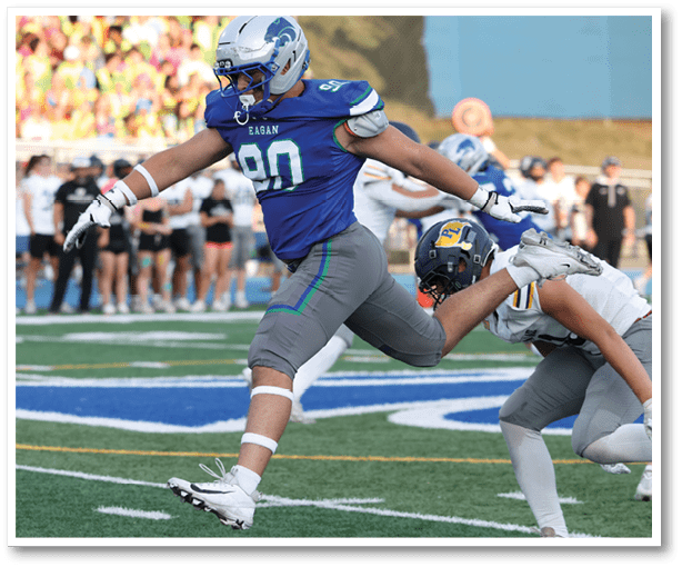 A football player is kicking a football on a field. Description generated by AI