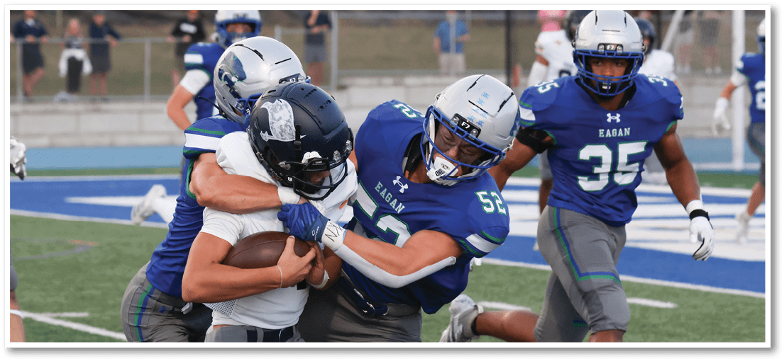 A group of football players on a field. Description generated by AI