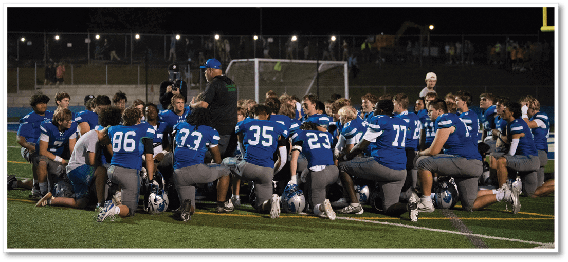 A group of football players on a field. Description generated by AI