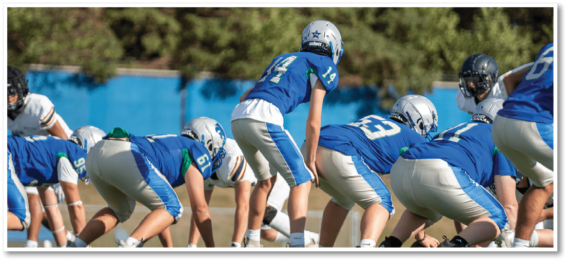 A group of football players on a field. Description generated by AI