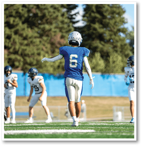 A football player wearing a black jersey with the number 6 on it. Description generated by AI