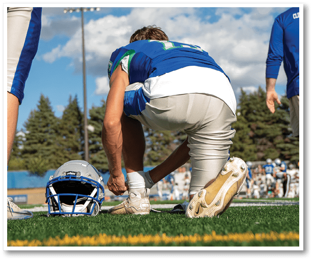 A football player is kicking a football on a field. Description generated by AI